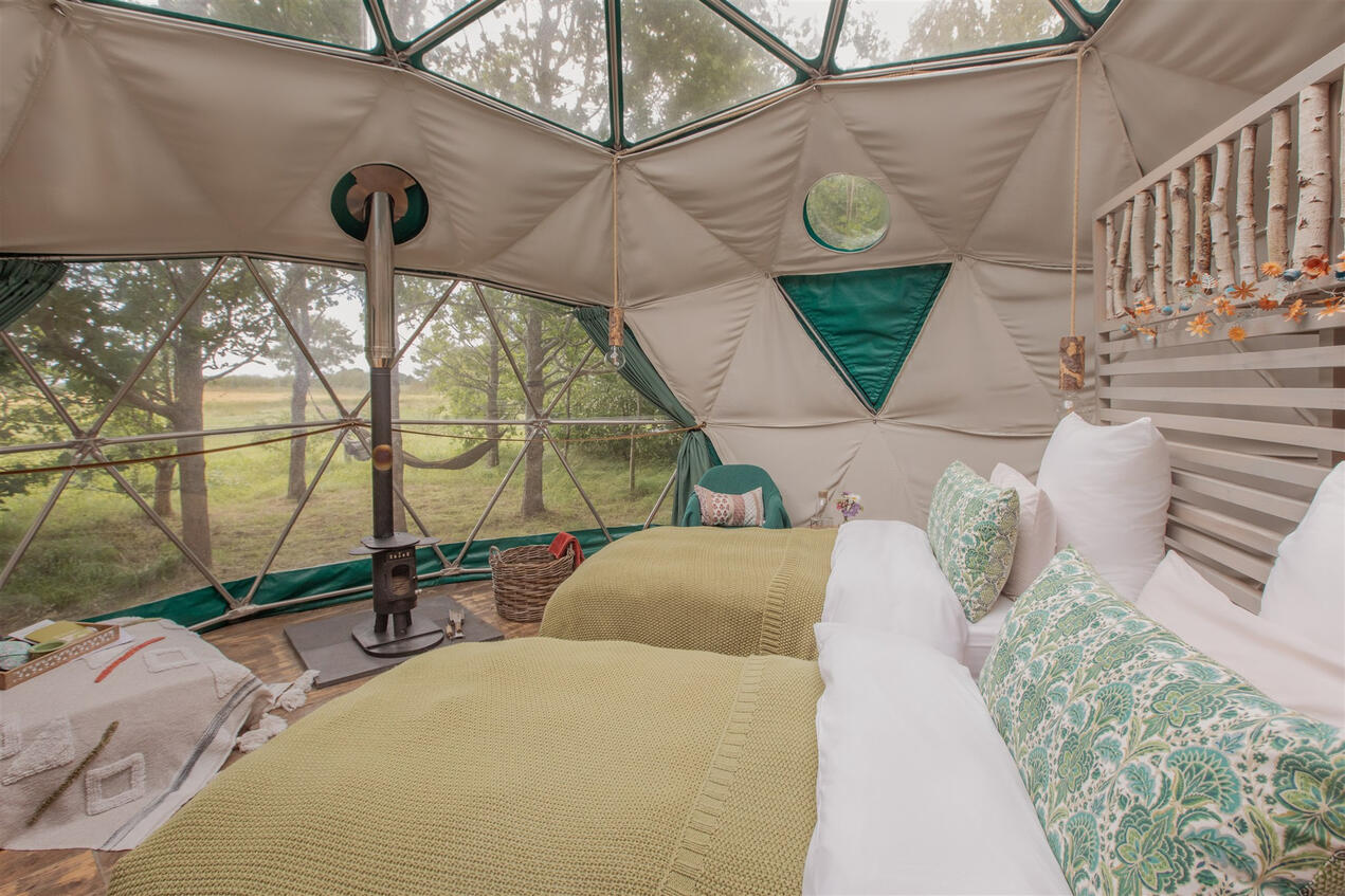 Wide shot of a movement facilitator in a dome space, mid-pose, during a wellness photography session