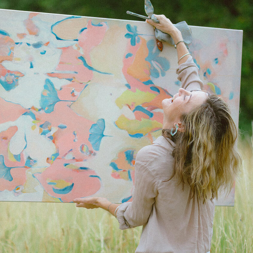 Branding photoshoot for Lincolnshire artist, holding painting and laughing.