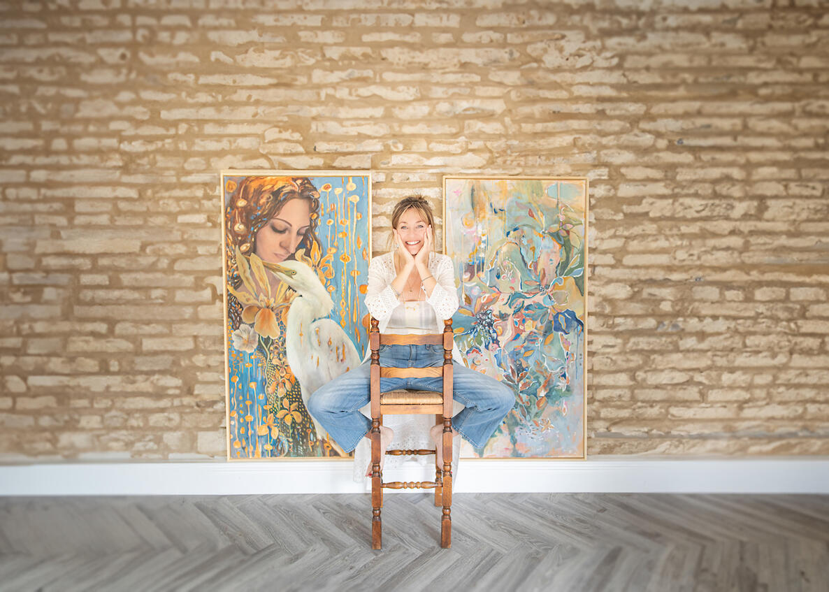 Portrait of Lincolnshire artist standing between her paintings