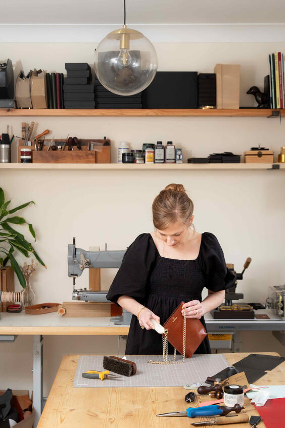Branding photography of Lincolnshire leather maker finishing a handbag.